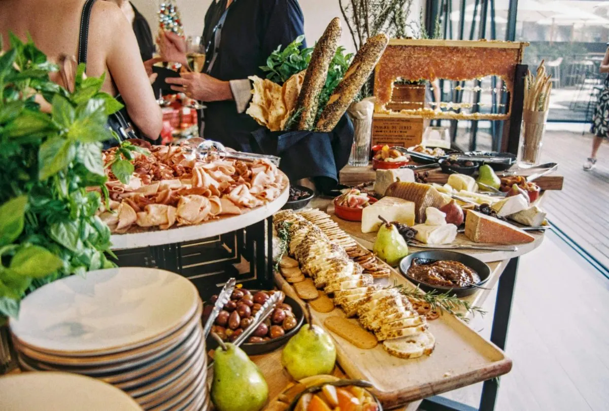 Mesa de frios com tábua de queijos, frutas, pães e favo de mel para os convidados